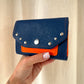 PORTE MONNAIE BLEU/ORANGE CLOUTÉ