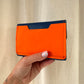 PORTE MONNAIE BLEU/ORANGE CLOUTÉ